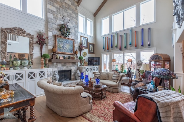 living room with a fireplace, wood-type flooring, and high vaulted ceiling