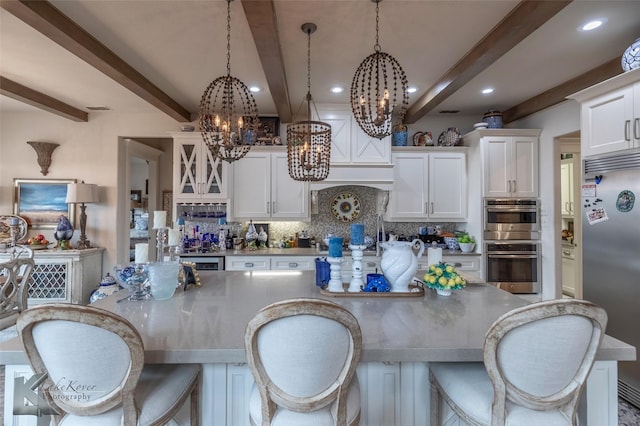 kitchen with white cabinetry, appliances with stainless steel finishes, decorative light fixtures, and decorative backsplash