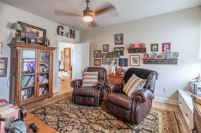 living area with hardwood / wood-style floors and ceiling fan