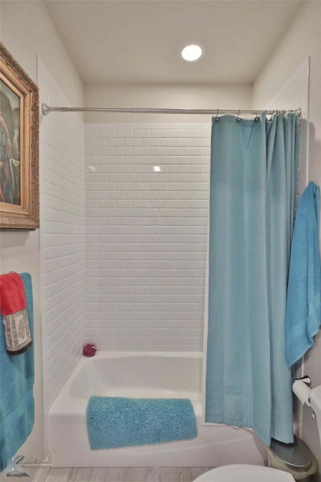 bathroom with shower / tub combo with curtain and toilet