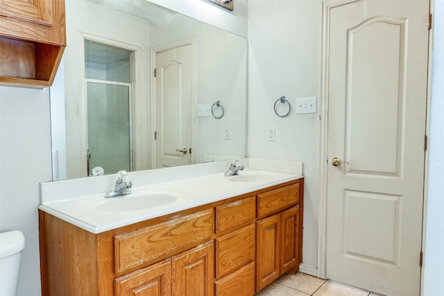 bathroom featuring tile patterned flooring, vanity, toilet, and walk in shower