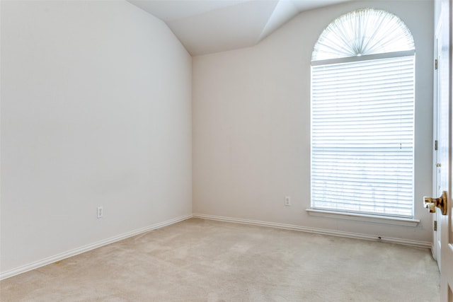 empty room with vaulted ceiling and light carpet