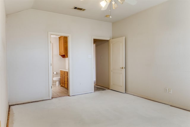 unfurnished bedroom featuring vaulted ceiling and connected bathroom