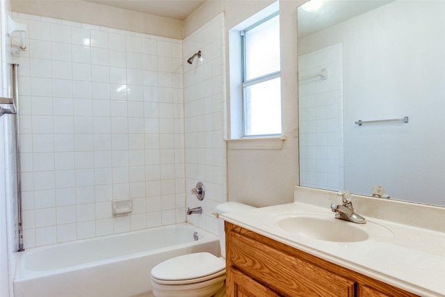 full bathroom featuring tiled shower / bath, vanity, and toilet