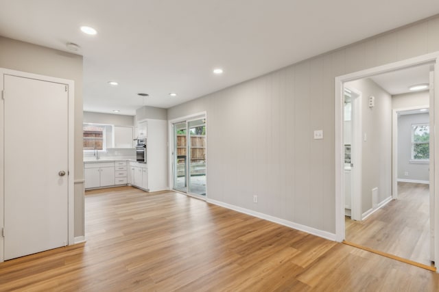 unfurnished living room with sink and light hardwood / wood-style flooring