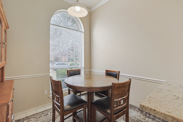 dining space featuring tile patterned floors and ornamental molding