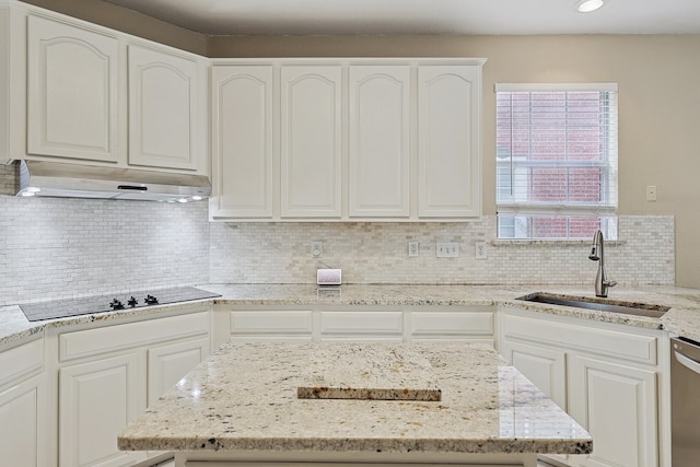 kitchen featuring sink, light stone countertops, white cabinets, and black electric stovetop