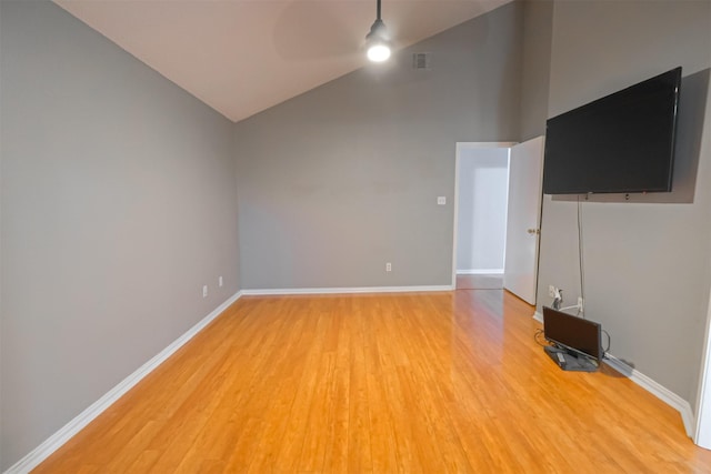 unfurnished living room with ceiling fan, wood-type flooring, and high vaulted ceiling