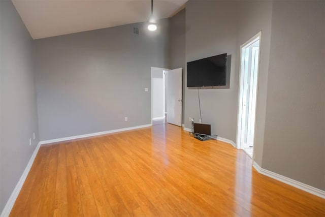 unfurnished living room featuring vaulted ceiling and hardwood / wood-style floors