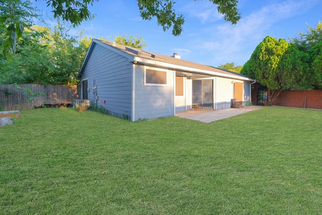 rear view of house featuring a yard and a patio area