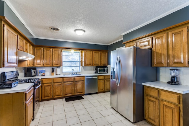 kitchen with sink, crown molding, light tile patterned floors, appliances with stainless steel finishes, and decorative backsplash