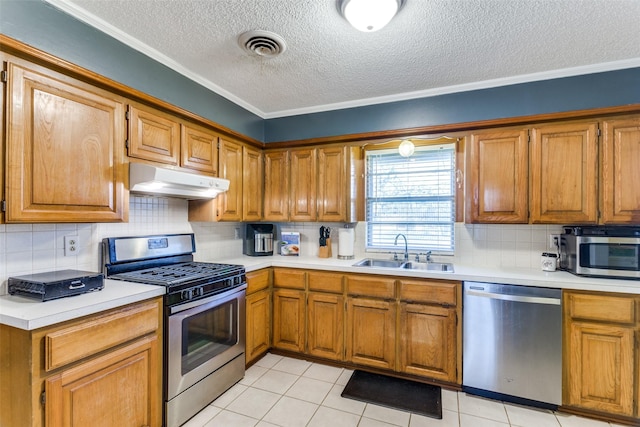 kitchen featuring sink, tasteful backsplash, a textured ceiling, light tile patterned floors, and stainless steel appliances