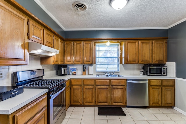 kitchen featuring appliances with stainless steel finishes, sink, light tile patterned floors, and backsplash