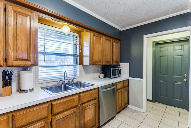 kitchen featuring sink, ornamental molding, light tile patterned floors, stainless steel appliances, and a textured ceiling