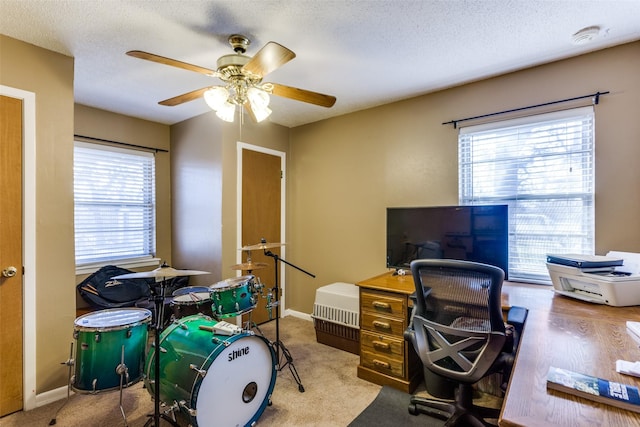 carpeted office space with ceiling fan and a textured ceiling