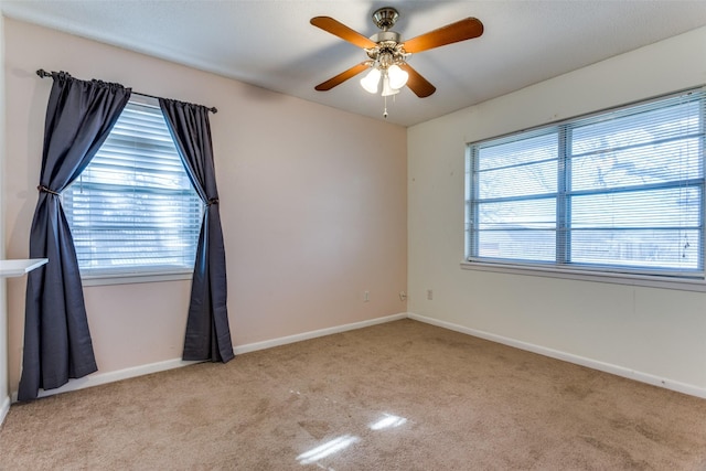 empty room with a healthy amount of sunlight, light colored carpet, and ceiling fan