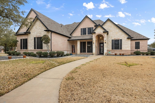 french provincial home featuring a front yard