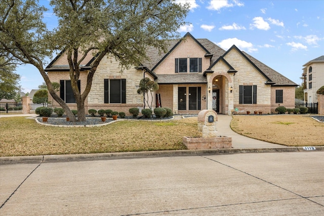 french country style house featuring a front yard