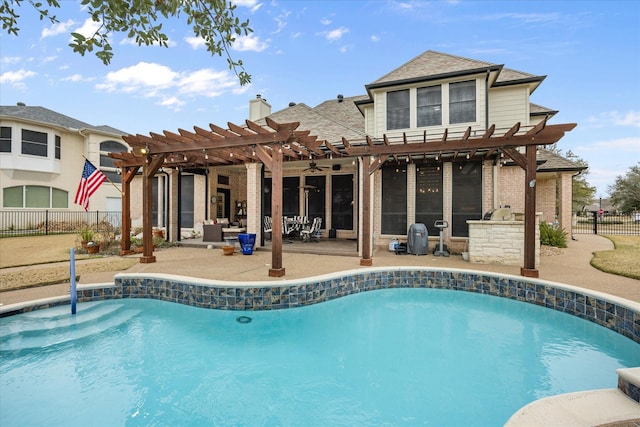 back of property with a fenced in pool, a pergola, exterior kitchen, and a patio area