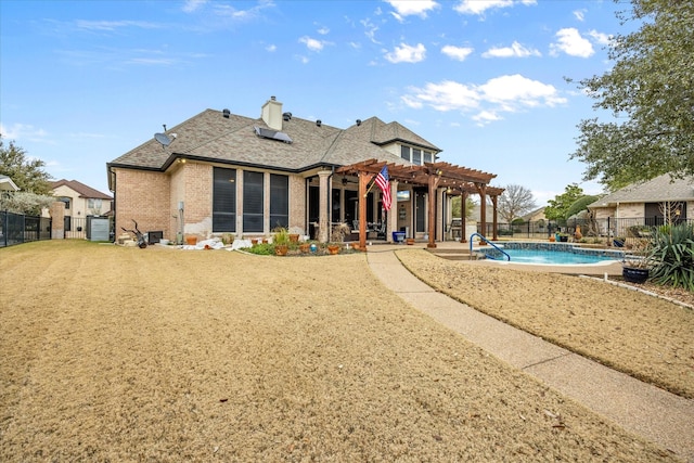 back of house with a fenced in pool, solar panels, and a pergola