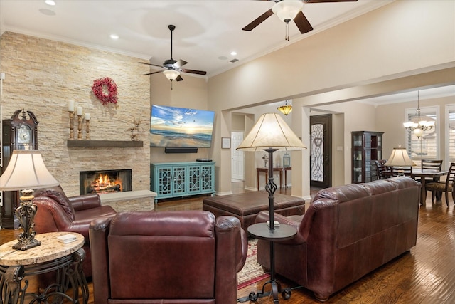 living room with crown molding, a stone fireplace, dark hardwood / wood-style flooring, and ceiling fan with notable chandelier