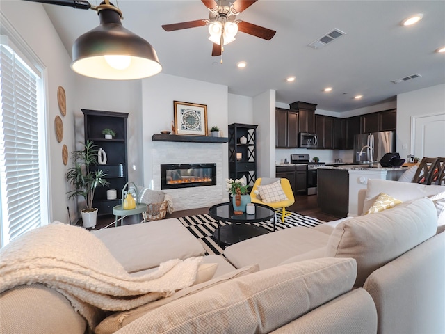 living room featuring a wealth of natural light, a glass covered fireplace, and visible vents