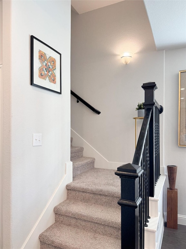 stairs featuring wood finished floors and baseboards