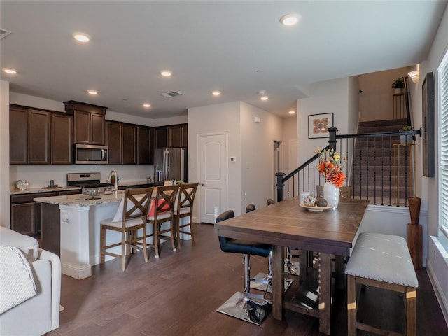 dining area featuring dark wood-style floors, stairway, visible vents, and recessed lighting