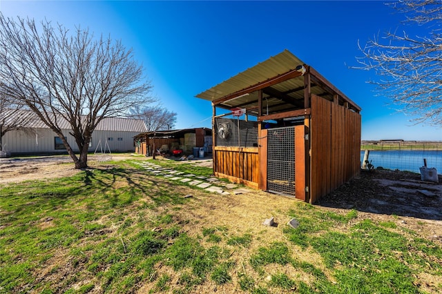 view of yard featuring an outbuilding and a water view