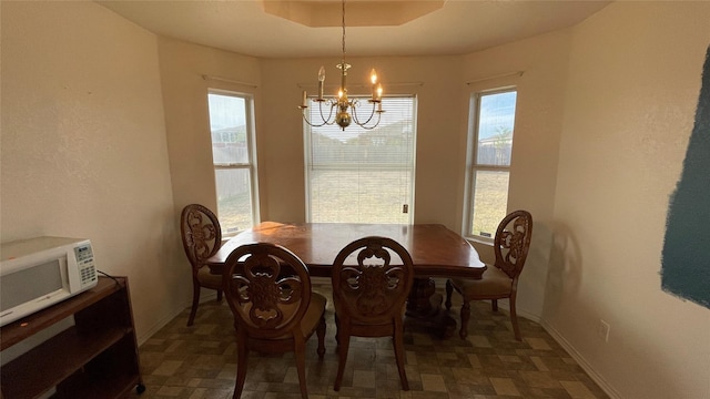 dining room featuring a notable chandelier and a raised ceiling