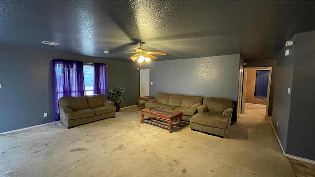 living room with a textured ceiling, ceiling fan, and carpet