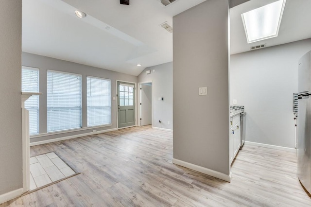 entryway with vaulted ceiling and light hardwood / wood-style floors