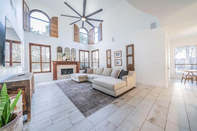 720 Amistad Dr, Prosper, TX 75078 - living room featuring a ceiling fan, plenty of natural light, a fireplace, light wood finished floors, and a high ceiling