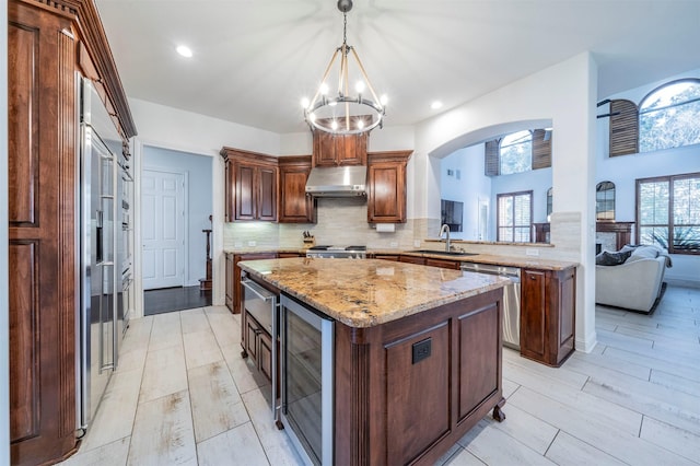 720 Amistad Dr, Prosper, TX 75078 - kitchen featuring stainless steel dishwasher, beverage cooler, under cabinet range hood, a center island, and a sink