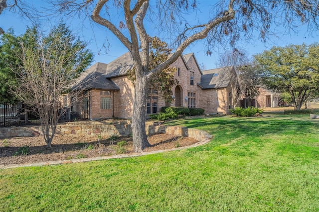 view of front of home featuring a front lawn, cooling unit, fence, and brick siding