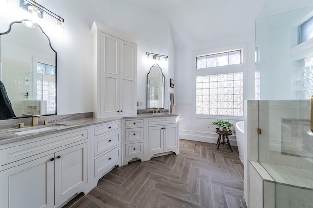 720 Amistad Dr, Prosper, TX 75078 - bathroom with a stall shower, plenty of natural light, double vanity, a soaking tub, and a wainscoted wall