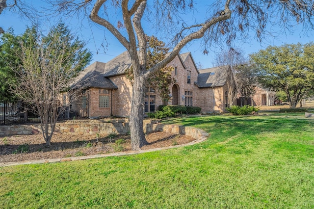 720 Amistad Dr, Prosper, TX 75078 - tudor home with brick siding, a front yard, and roof with shingles
