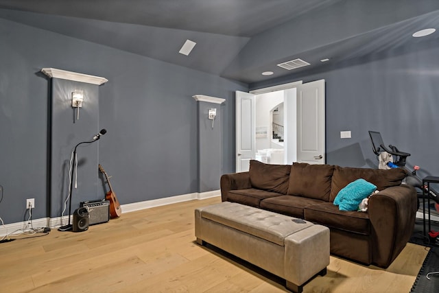 living room featuring vaulted ceiling and light hardwood / wood-style flooring