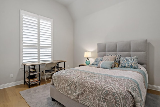 bedroom with lofted ceiling and hardwood / wood-style floors