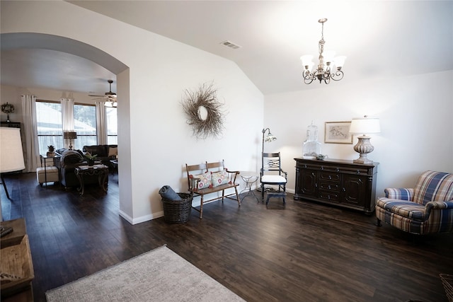 living area featuring dark wood-type flooring, lofted ceiling, and ceiling fan with notable chandelier