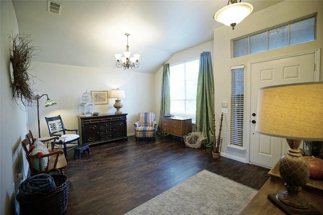 entrance foyer featuring vaulted ceiling, an inviting chandelier, and dark hardwood / wood-style flooring