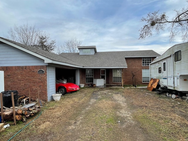 back of property featuring central AC and a garage