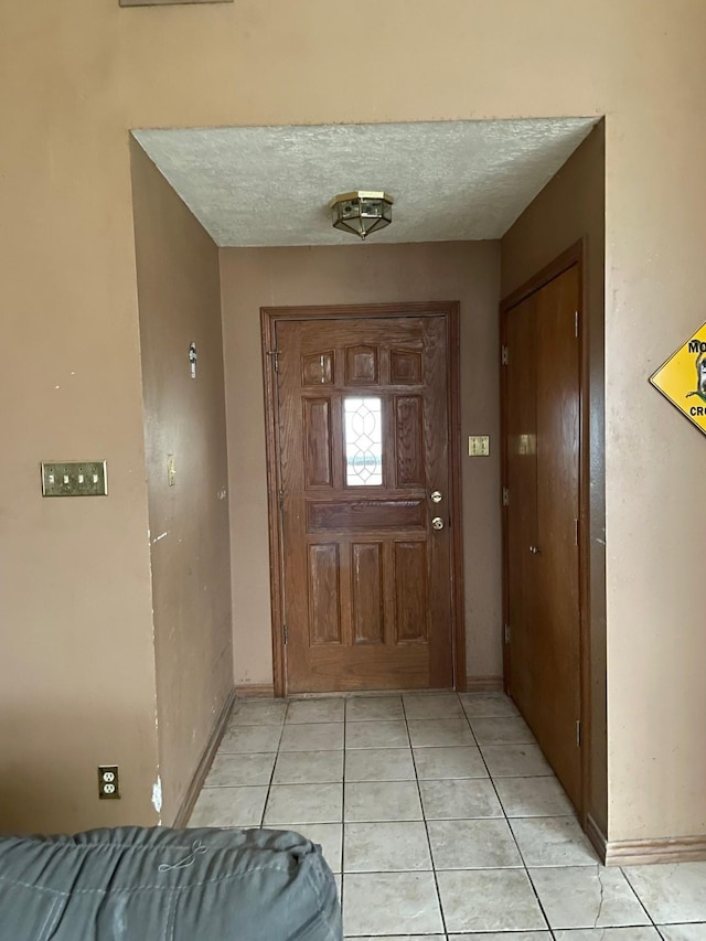 foyer with light tile patterned floors and a textured ceiling