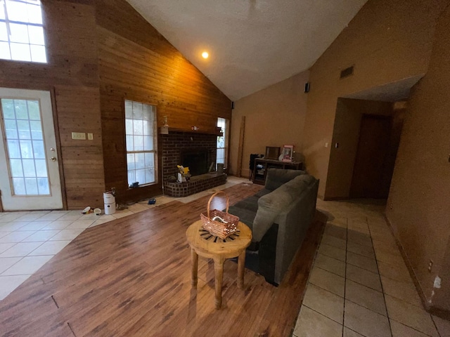 living room featuring light tile patterned floors, a fireplace, and high vaulted ceiling