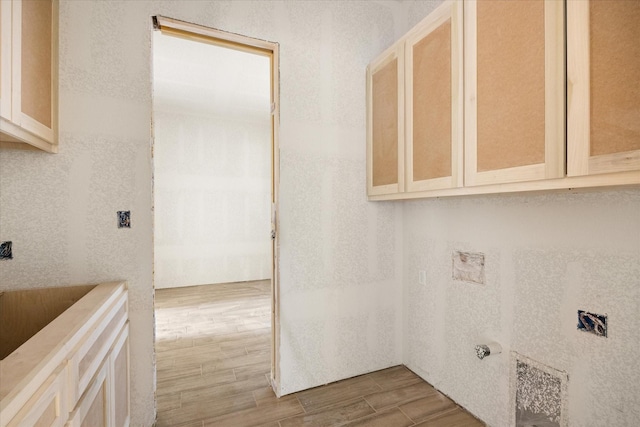 laundry room featuring wood tiled floor and cabinet space