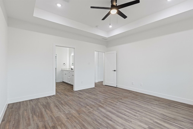 5065 Willie St, Fort Worth, TX 76105 - unfurnished bedroom featuring a raised ceiling, wood finished floors, baseboards, recessed lighting, and ensuite bath