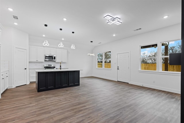 5065 Willie St, Fort Worth, TX 76105 - kitchen with stainless steel appliances, recessed lighting, wood finished floors, light countertops, and white cabinetry