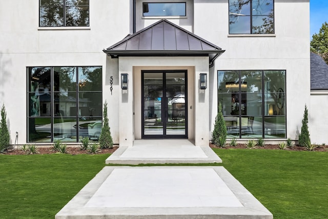 entrance to property featuring a lawn and french doors