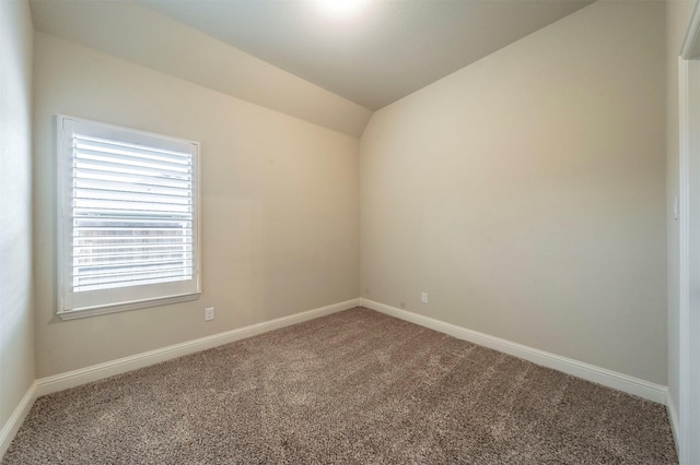 carpeted spare room featuring lofted ceiling