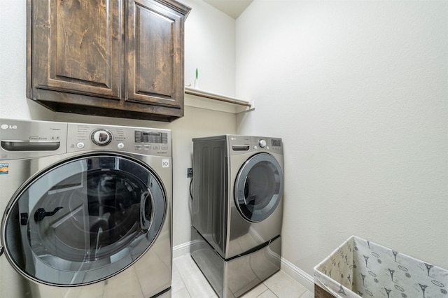 washroom with cabinets, independent washer and dryer, and light tile patterned flooring